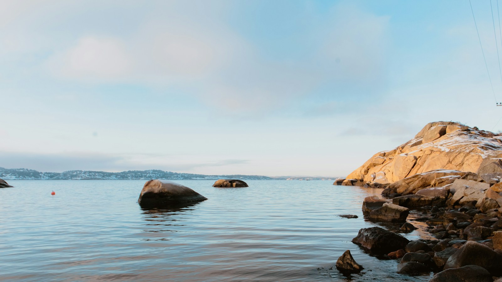Stille hav og åpne vannflater ved svaberg i varmt lys på Folehavna i Sandefjord.